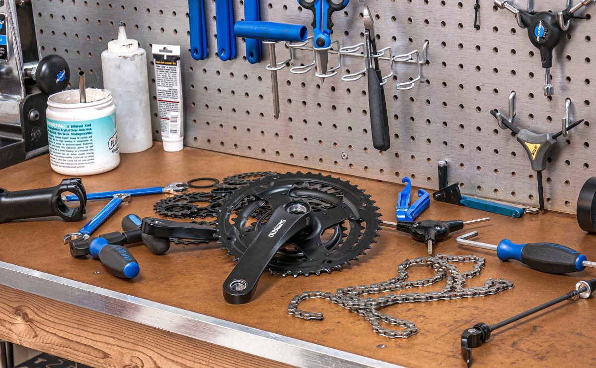 Image of a bicycle chain with other bike parts on a table. Source: tom conway, unsplash