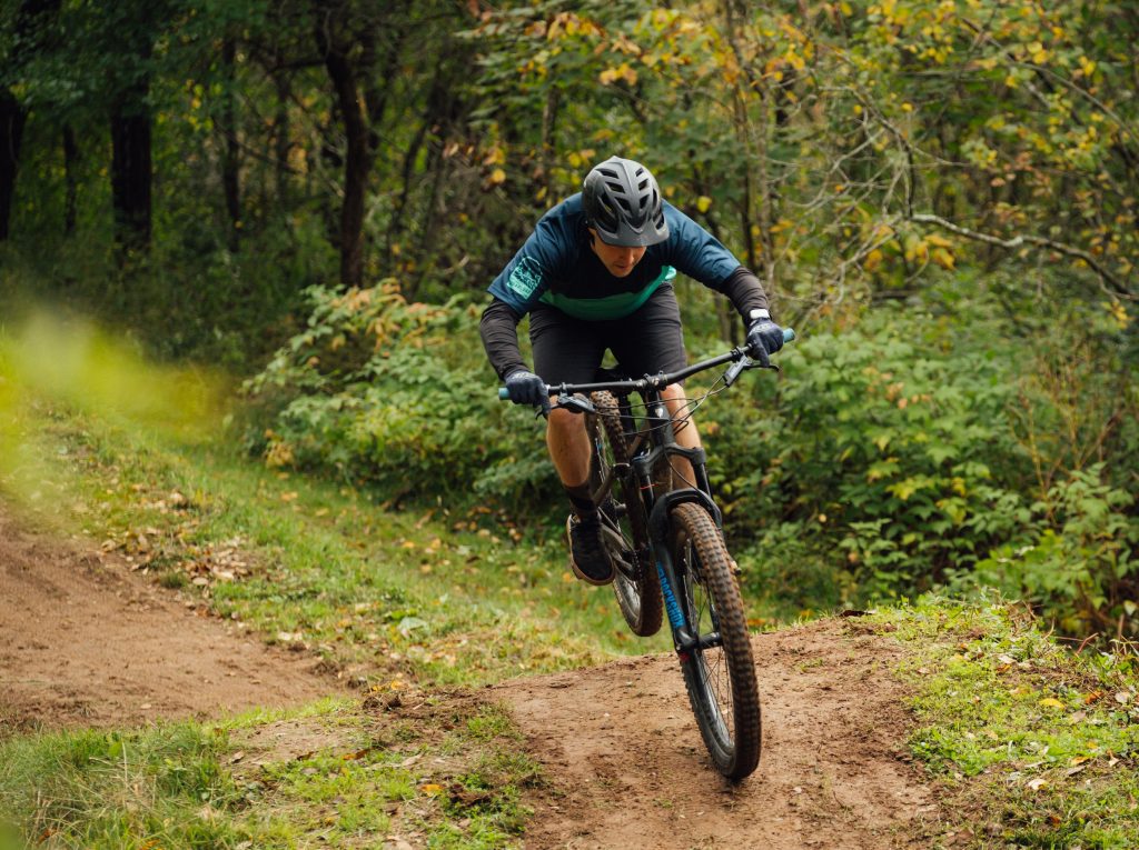 Image of a man riding a bicycle in the forest source tim foster unsplash