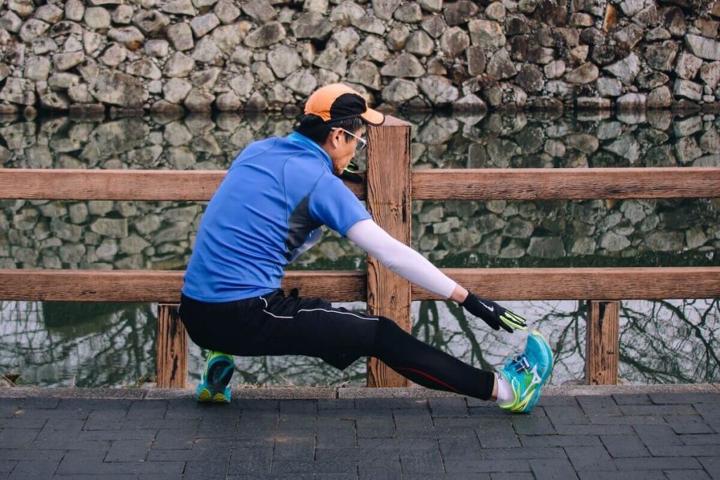 Man stretching to make sure riding a fixie isn't bad for your knees.